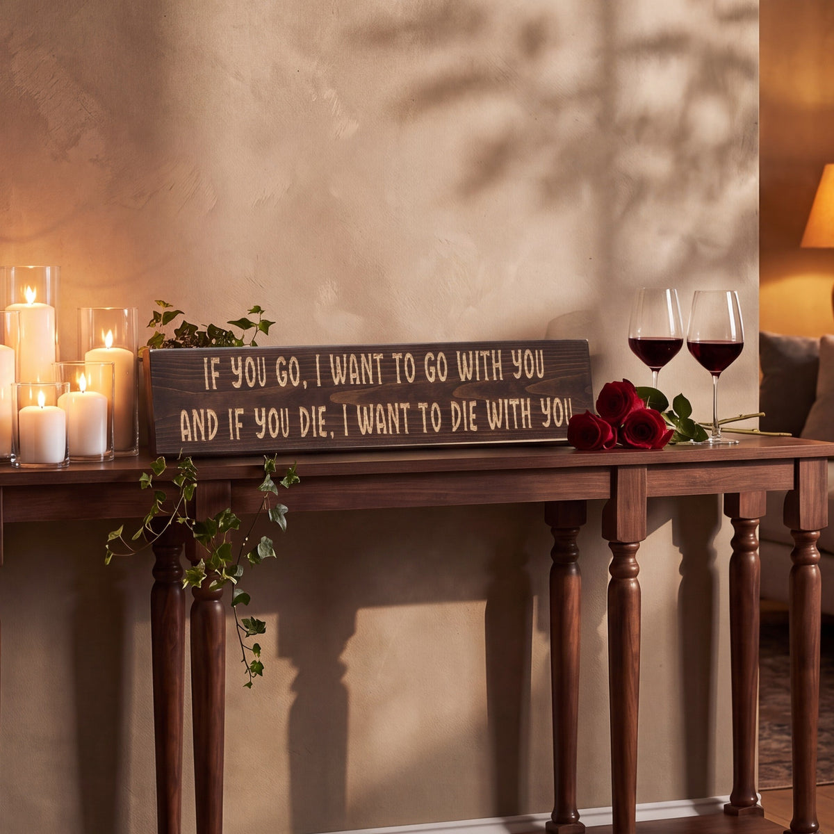 The If You Go, I Want to Go With You sign leaning on a console table among candles, red roses and two glasses of wine