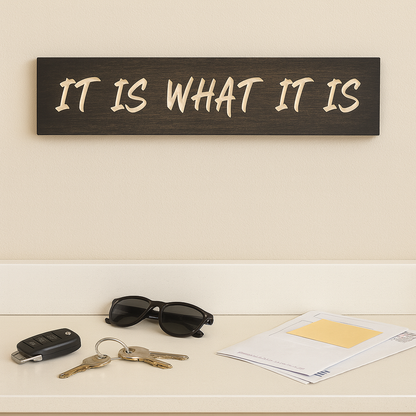 Inspirational farmhouse quote sign “It Is What It Is” displayed in an entryway with keys and mail.