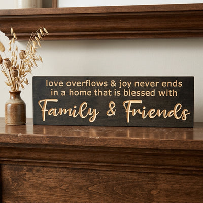 A dark stained Love Sign for Home rests on a rich wooden mantel, with dried plants in a vase nearby, from Bluegrass Gifts
