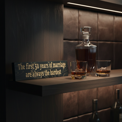 "Rustic carved wood marriage sign styled on a modern bar shelf next to a bourbon decanter, perfect for a man cave or den."
