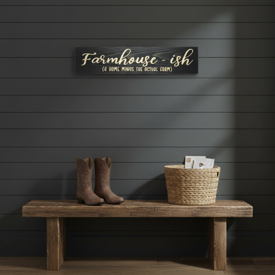 The "Farmhouse-ish" sign styled above a wooden bench in a modern entryway. A cheeky "house rules" statement piece carved in solid hardwood by local Kentucky craftsmen.
