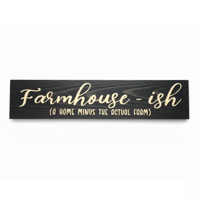 A high-contrast studio shot of the "Farmhouse-ish (A Home Minus The Actual Farm)" sign. Crafted from solid Kentucky hardwood with a midnight ebony finish and natural wood recessed text.