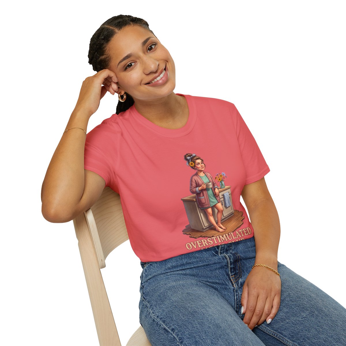 A smiling woman in a coral pink crop top, leaning on a chair, showing the "Overstimulated Shirt - Overstimulated Moms Club"
