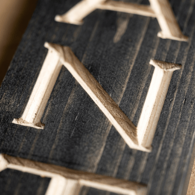 Macro close-up of CNC carved letters on the vertical pantry wood sign revealing real pine grain, hand-finished depth, and authentic wood craftsmanship from Kentucky.