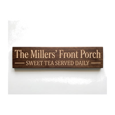 Personalized The Millers' Front Porch sign carved into solid wood in a Dark Walnut finish, straight on, on a white background (studio photo)