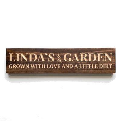 Personalized Linda's Garden sign carved into solid wood in a Dark Walnut finish, straight on, on a white background (studio photo)