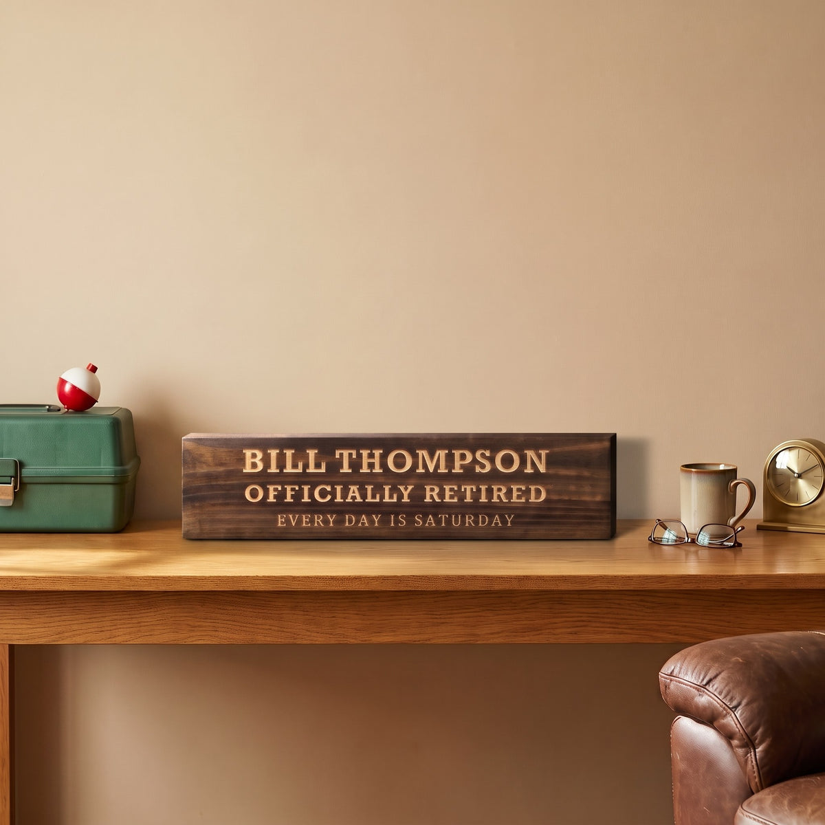 Bill Thompson personalized wood sign standing on an oak desk beside a green tackle box with a fishing bobber, a coffee mug, reading glasses and a brass clock