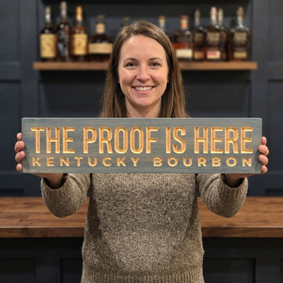Bourbon Sign — The Proof Is Here | Kentucky Carved Wood — shown to scale, held — Bluegrass Gifts