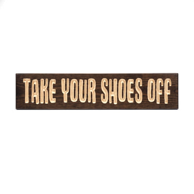 Take Your Shoes Off sign carved into solid wood in a Dark Walnut stain, straight on, on a white background