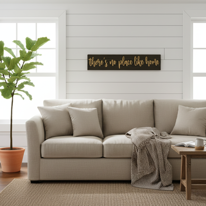 Rustic “There’s No Place Like Home” wooden sign hanging above a sofa in a bright living room.