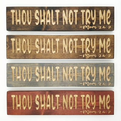 A stack of four Bluegrass Gifts "Thou Shalt Not Try Me" wooden signs showcasing different available stain color options.