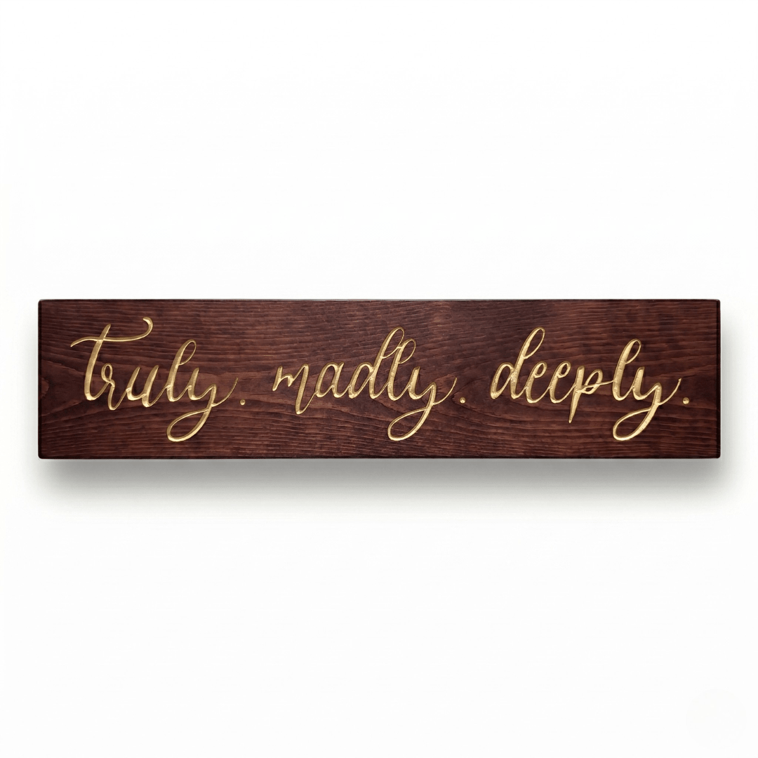 Truly Madly Deeply CNC-carved solid wood sign with elegant gold script lettering on a rich dark walnut finish, shown on a clean white background