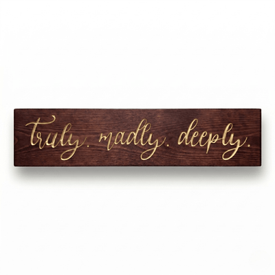Truly Madly Deeply CNC-carved solid wood sign with elegant gold script lettering on a rich dark walnut finish, shown on a clean white background