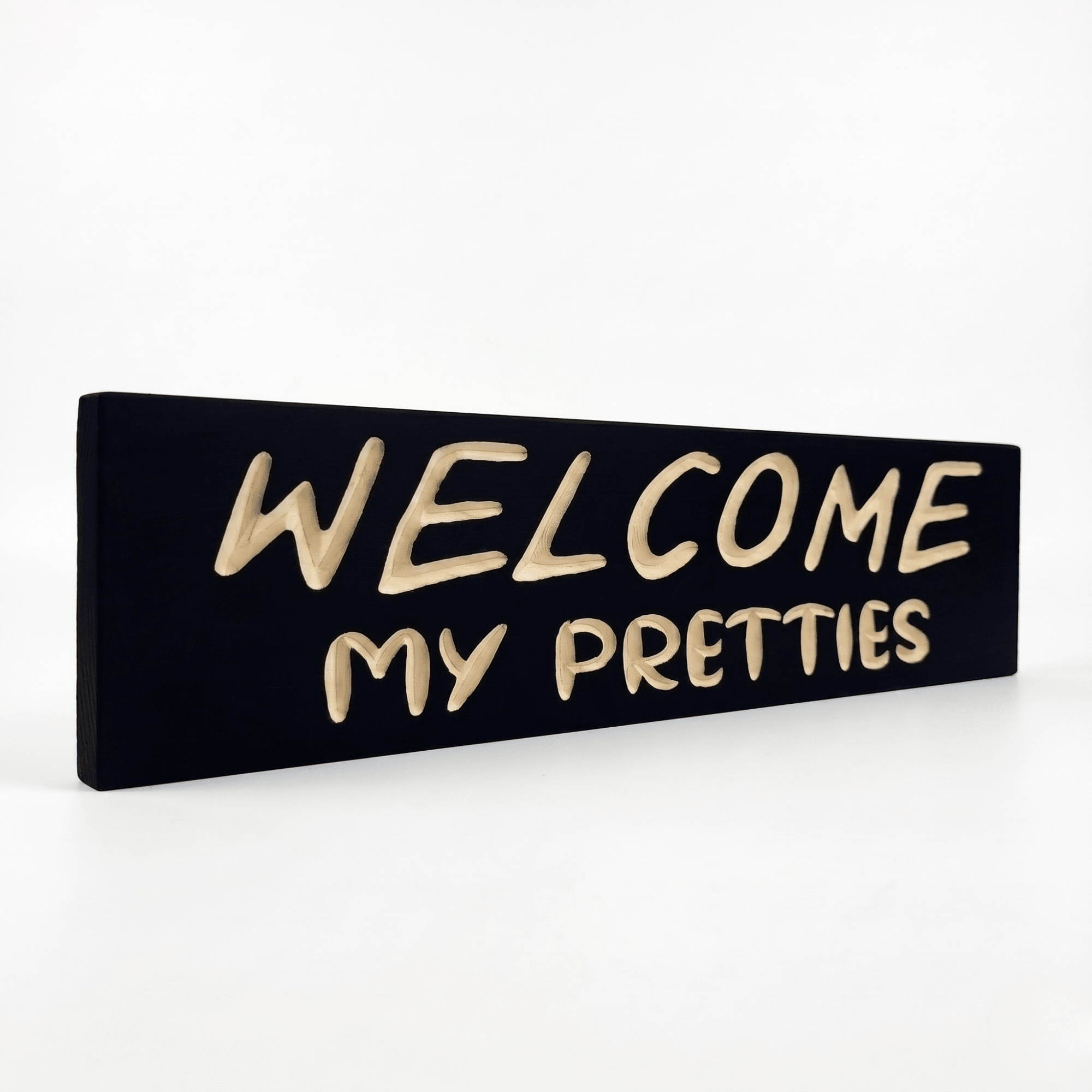 Angled view of the solid wood Welcome My Pretties spooky welcome sign with carved lettering.