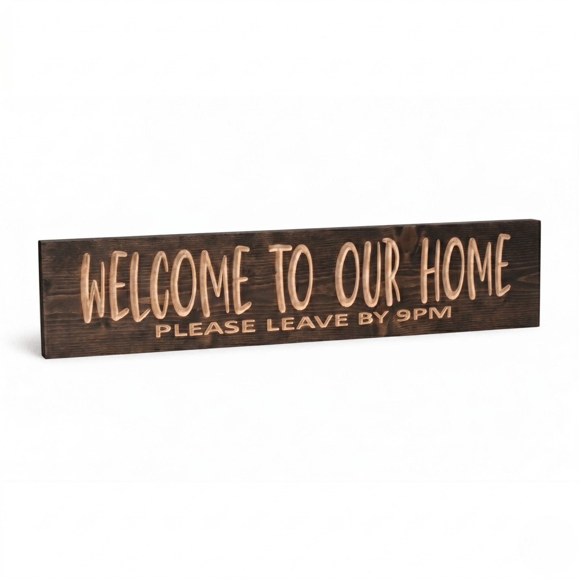 Welcome to Our Home Please Leave by 9PM CNC-carved wood sign in dark walnut finish shown at angle on white studio background