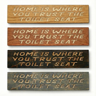 Four color variations of the "Trust The Toilet Seat" sign showing light oak, cherry, dark walnut, and weathered grey wood finishes.