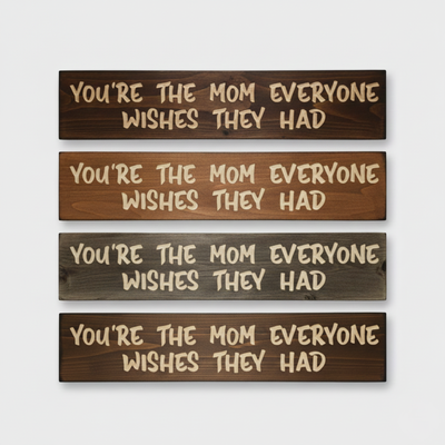 Stack of four "You're The Mom Everyone Wishes They Had" signs showing different rustic wood stain finishes.