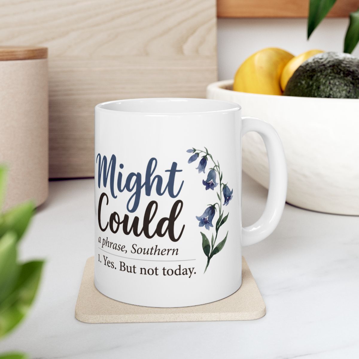The white Mug With Sayings, featuring the "Might Could" phrase, rests on a light coaster in a modern kitchen setting