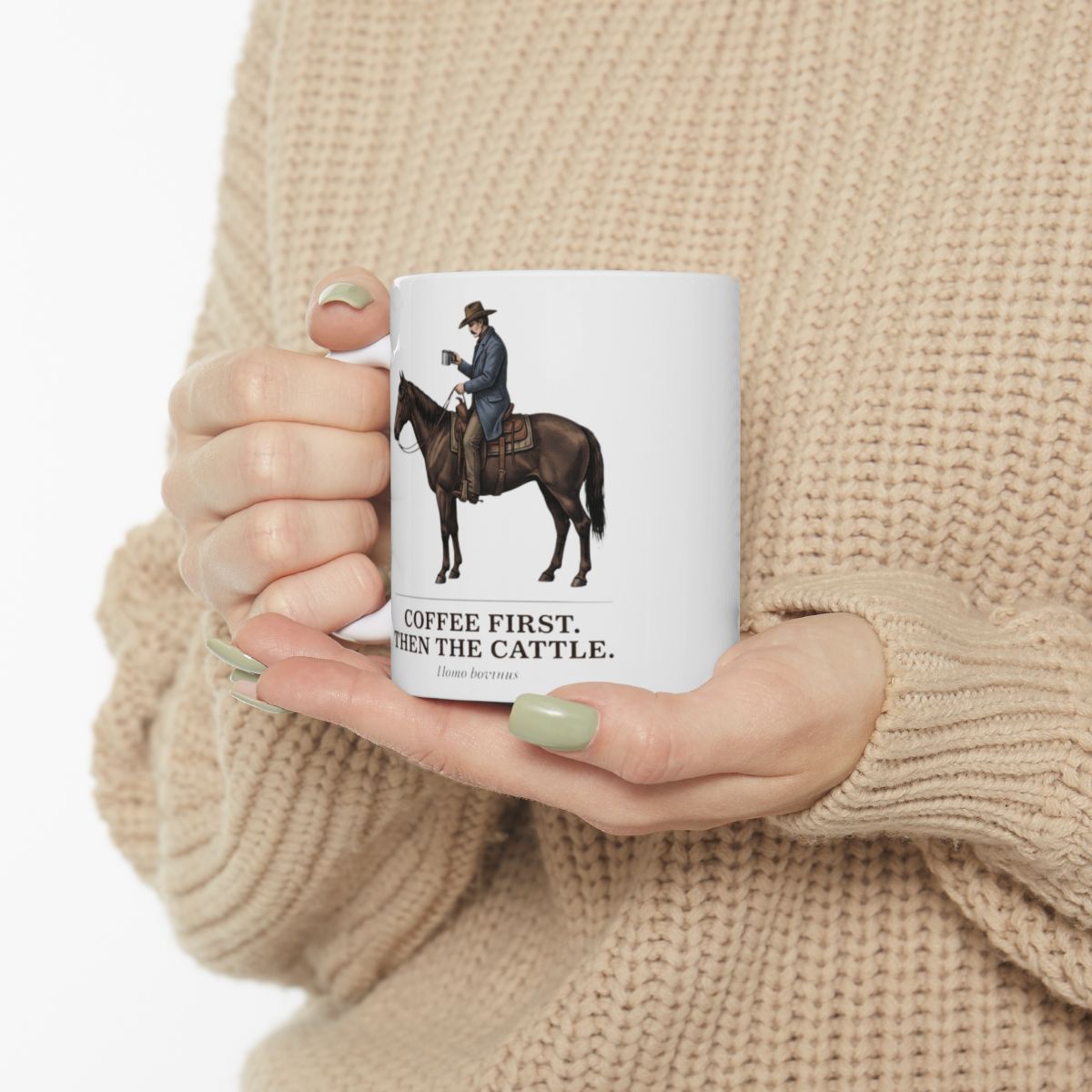A person in a light sweater holds the Cowboy Coffee Mug with both hands, showing light green nail polish