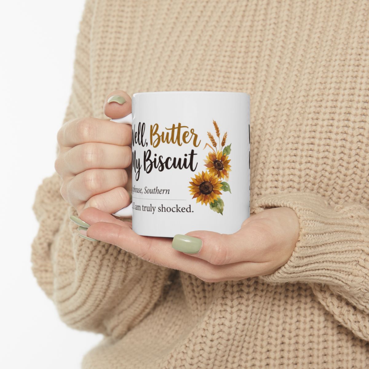 A person in a light-colored sweater holds a white ceramic mug with both hands, showing the "Well, Butter My Biscuit" design, a comfortable fit for Mugs for Women