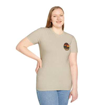 Woman with long hair, standing and smiling, wearing a light tan Y'all Shirt with a small round graphic on the left chest