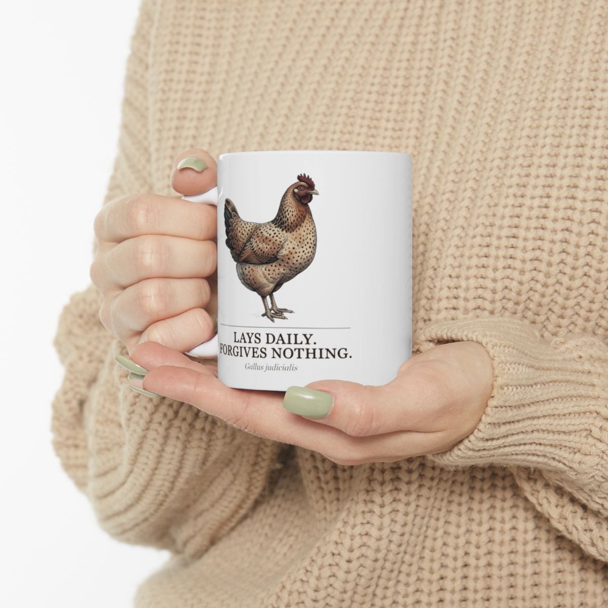 Hands in a beige sweater gently holding a white Chicken Coffee Mug, showing the hen illustration clearly
