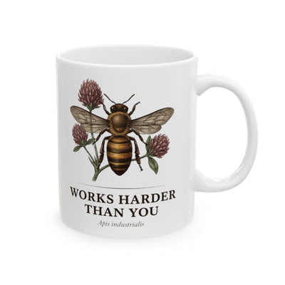 A slightly different front angle of the white Bee Coffee Mug, displaying the full bee and clover design and text on a white surface