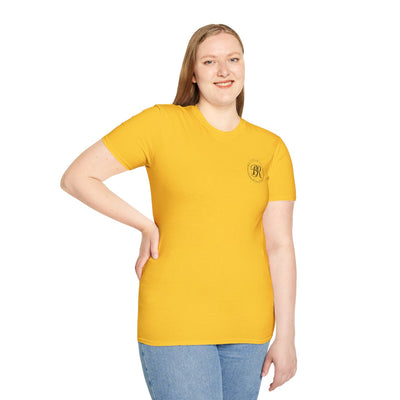 A woman smiling, looking forward, wearing a mustard yellow Sweet Tea Shirt with the small "Bluegrass Roots" logo on the left chest