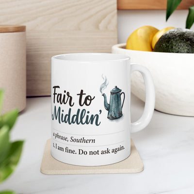 A "Fair to Middlin'" Coffee Mug Gift on a light coaster in a kitchen with fruit and a cutting board