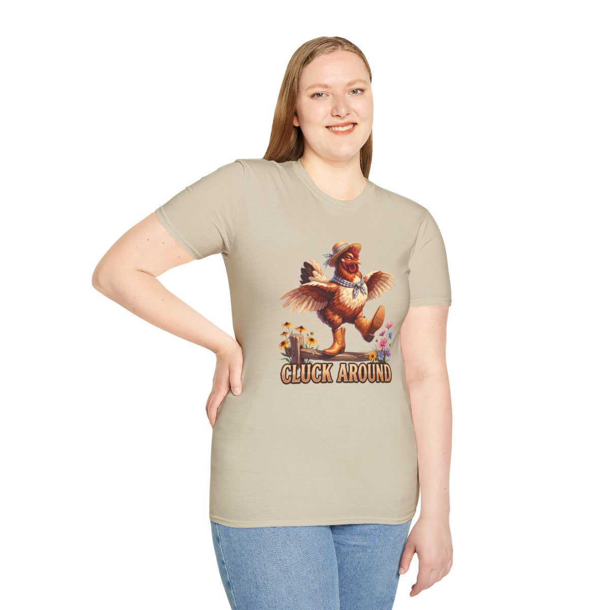 A smiling woman stands with one hand on her hip, modeling the light beige Chicken Shirt - Cluck Around