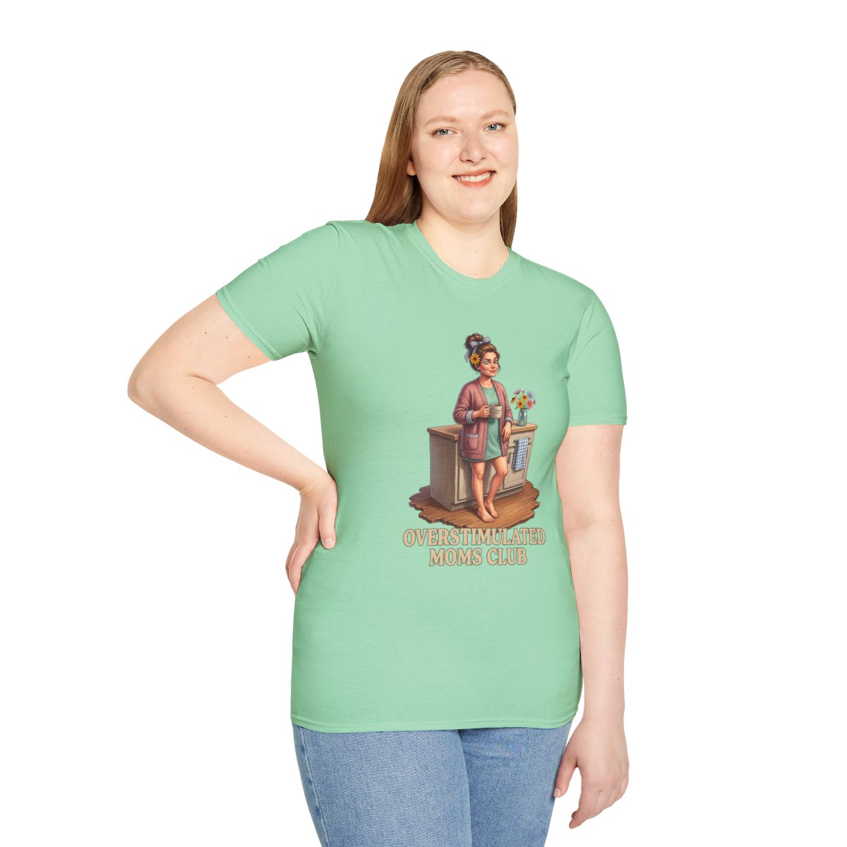 A woman stands smiling, wearing a mint green Overstimulated Shirt - Overstimulated Moms Club, with her hand on her hip