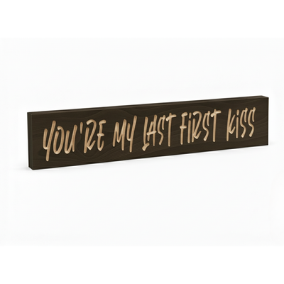 Angled view of the “You’re My Last First Kiss” carved wooden sign in dark walnut finish, handmade romantic wall décor.